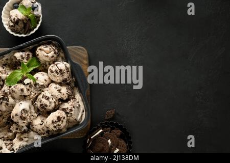 Gelato con biscotti al cioccolato su sfondo nero. Vista dall'alto. Spazio di copia Foto Stock