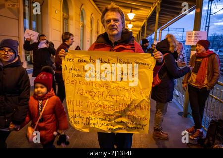 Volontariato offre gite e alloggio con il suo cartello in cartone presso la stazione ferroviaria di Przemysl, in Polonia, non lontano dal confine polacco-ucraino. Qui i rifugiati sono dotati di cibo e vestiti caldi. Da qui vengono inoltrati ad alloggi su larga scala o collettivi. Foto Stock