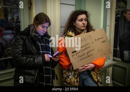 Volontariato offre gite e alloggio con il suo cartello in cartone presso la stazione ferroviaria di Przemysl, in Polonia, non lontano dal confine polacco-ucraino. Qui i rifugiati sono dotati di cibo e vestiti caldi. Da qui vengono inoltrati ad alloggi su larga scala o collettivi. Foto Stock