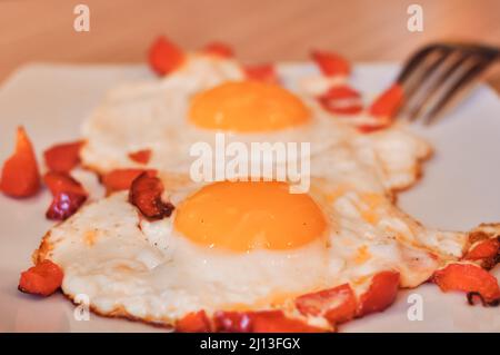 Due uova fritte in padella con pepe rosso colazione mattina. Foto di alta qualità Foto Stock