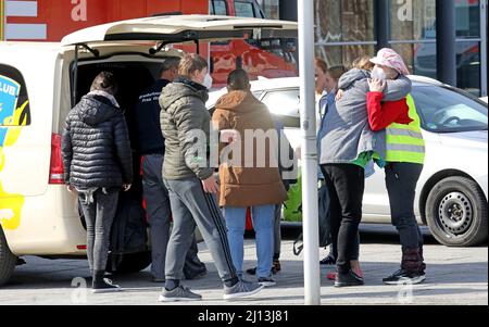 Rostock, Germania. 22nd Mar 2022. Di fronte all'Hansemesse, un assistente porta i rifugiati ucraini in un taxi e dice Arrivederci a loro. Fino ad oggi, l'Hansemesse era il punto di contatto centrale per i rifugiati ucraini nel Meclemburgo-Pomerania occidentale. Ora il centro di accoglienza iniziale dello stato di Meclemburgo-Pomerania occidentale a Stern Buchholz è quello di assumere questo compito, perché la registrazione dei rifugiati all'Hansemesse non può essere gestita senza problemi. Credit: Bernd Wüstneck/dpa-Zentralbild/dpa/Alamy Live News Foto Stock