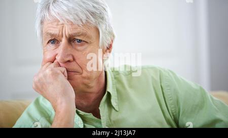 Qualcosa ha avuto da dare.... Colpo di un uomo anziano profondo nel pensiero a casa. Foto Stock