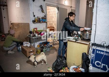 Kiev, Ucraina. 21st Mar 2022. Una donna ha visto cucinare in un seminterrato vicino all'esplosione che ha distrutto parti di un centro commerciale a Kiev. I residenti di Kyiv sono stati rifugio in scantinati e bunker da quando la Russia ha iniziato ad invadere l'Ucraina il 24 febbraio 2022. (Foto di Laurel Chor/SOPA Images/Sipa USA) Credit: Sipa USA/Alamy Live News Foto Stock