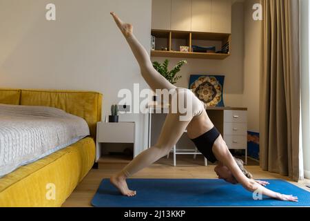 la donna sta praticando lo yoga a casa Foto Stock