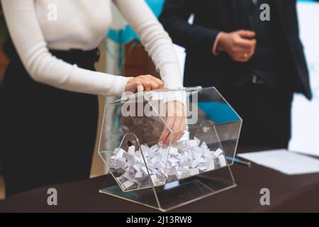 Processo di estrazione dei premi, estrazione di un numero vincente di lotteria macchina, tamburo di lotteria con bingo palle e vincita dei biglietti in occasione dell'evento con l'ospite e Foto Stock