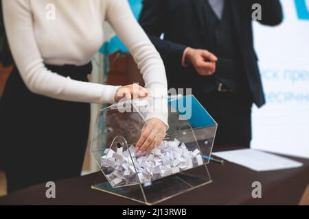 Processo di estrazione dei premi, estrazione di un numero vincente di lotteria macchina, tamburo di lotteria con bingo palle e vincita dei biglietti in occasione dell'evento con l'ospite e Foto Stock