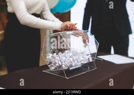 Processo di estrazione dei premi, estrazione di un numero vincente di lotteria macchina, tamburo di lotteria con bingo palle e vincita dei biglietti in occasione dell'evento con l'ospite e Foto Stock