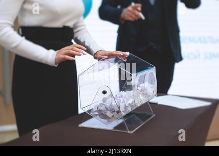 Processo di estrazione dei premi, estrazione di un numero vincente di lotteria macchina, tamburo di lotteria con bingo palle e vincita dei biglietti in occasione dell'evento con l'ospite e Foto Stock