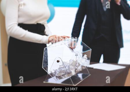 Processo di estrazione dei premi, estrazione di un numero vincente di lotteria macchina, tamburo di lotteria con bingo palle e vincita dei biglietti in occasione dell'evento con l'ospite e Foto Stock