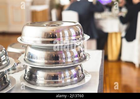 Processo di servire cena di lusso in un piatto di chiodi di garofano con un coperchio, cameriere che serve il pasto principale sotto piatto d'argento su un banchetto nel ristorante o Foto Stock