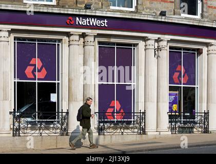 Uomo che cammina oltre il ramo della banca Natwest, su Cambridge Crescent, Harrogate, North Yorkshire, Inghilterra Regno Unito Foto Stock