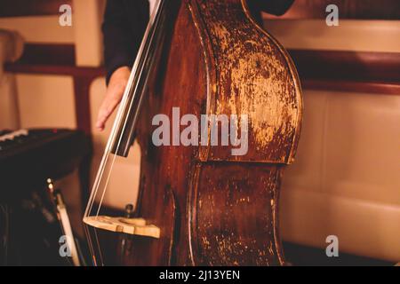 Concerto del vecchio violoncello retrò d'epoca contrabbasso con cantante e gruppo musicale durante il jazz orchestra band che suona musica, viola Foto Stock