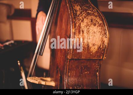 Concerto del vecchio violoncello retrò d'epoca contrabbasso con cantante e gruppo musicale durante il jazz orchestra band che suona musica, viola Foto Stock