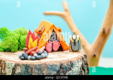 Campo turistico. Paesaggio plastificato con una tenda, un falò e uno zaino in mezzo alla foresta. Il concetto di eco-friendly ricreazione e envi Foto Stock