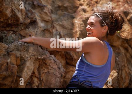 Sono nato per questo. Scatto di una femmina rock climber godendosi. Foto Stock