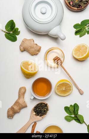 Vista dall'alto della tazza di tè vicino al miele e alla menta su sfondo bianco Foto Stock