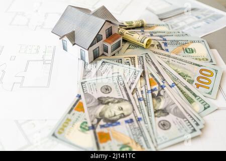Soldi contro lo sfondo della disposizione della casa. Stipendio per i costruttori. Posti vacanti per i costruttori. Formazione nelle professioni di costruzione. Foto Stock