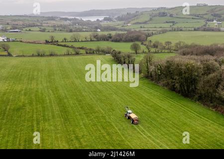 Rosscarbery, West Cork, Irlanda. 22nd Mar 2022. In una giornata calda ma molto intensa, l'agricoltore Ivan Jennings distribuisce il fertilizzante Sulphercan utilizzando un trattore Fendt 818 e uno spanditore Bredall. Ivan e suo fratello John fattoria caseificio e dissodamento su 350 ettari, con questo campo in preparazione per la produzione di insilato. Credit: AG News/Alamy Live News Foto Stock