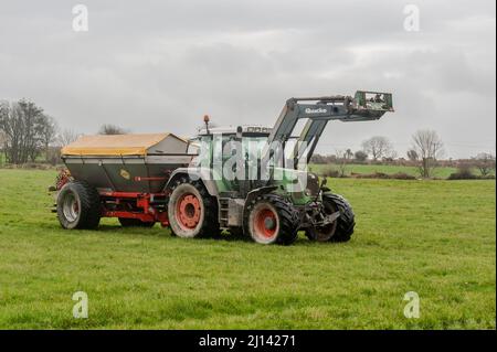 Rosscarbery, West Cork, Irlanda. 22nd Mar 2022. In una giornata calda ma molto intensa, l'agricoltore Ivan Jennings distribuisce il fertilizzante Sulphercan utilizzando un trattore Fendt 818 e uno spanditore Bredall. Ivan e suo fratello John fattoria caseificio e dissodamento su 350 ettari, con questo campo in preparazione per la produzione di insilato. Credit: AG News/Alamy Live News Foto Stock