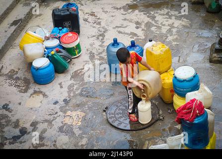 Kathmandu, Bagmati, Nepal. 22nd Mar 2022. Un bambino versa l'acqua in un altro vaso dopo il riempimento da un rubinetto di pietra tradizionale a Kathmandu, Nepal, 22 marzo 2022, la Giornata Mondiale dell'acqua. La gente della valle di Kathmandu deve ancora affrontare il problema della scarsità di acqua potabile a causa dell'aumento della popolazione e dell'urbanizzazione. (Credit Image: © Sunil Sharma/ZUMA Press Wire) Foto Stock