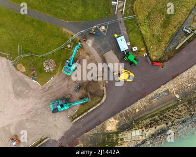 Vista aerea di un escavatore e di un dumper che lavora sulle difese costiere a Southsea Portsmouth. Vista dall'alto verso il basso dall'alto Foto Stock