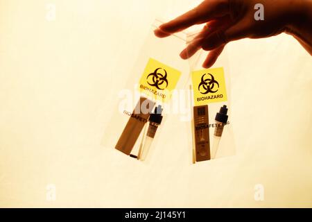 Test positivo per il covid in un sacchetto di plastica, test casa per il covid19, inquinamento del pianeta. Foto Stock