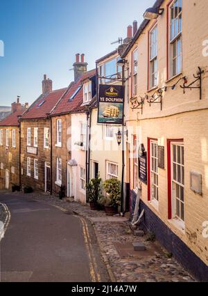 Ripida e stretta Kings Street che conduce alla spiaggia di Robin Hood's Bay, North Yorkshire. Foto Stock