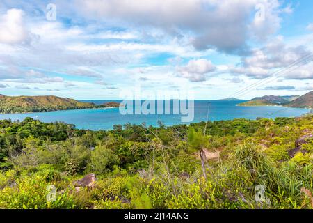 Vista panoramica dell'isola di Praslin, Seychelles, vista da Zimbabwe Point (Grand Fond), con lussureggiante vegetazione tropicale e acque turchesi. Foto Stock