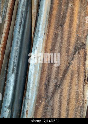 Il palo del vecchio foglio di zinco dopo la rimozione dalla casa di lavoro temporanea nel cantiere, vista frontale per lo sfondo. Foto Stock