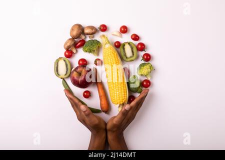Le mani tagliate da verdure e frutta disposte in cerchio da spazio copia su sfondo bianco Foto Stock