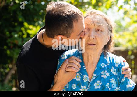 nonna molto vecchia e nipote adulto. Foto Stock