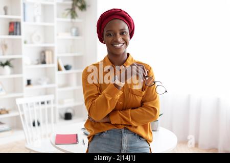 Allegra donna musulmana afroamericana in posa in ufficio Foto Stock
