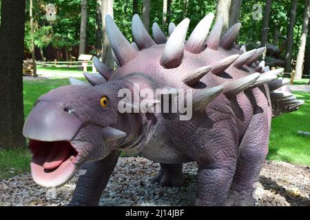 DINO PARK, KHARKOV - 8 AGOSTO 2021: Vista di un giorno della bellissima scultura di Dinosauri nel parco. Ankylosaurus, rettile preistorico, nel Parco dei Dinosauri Foto Stock