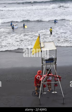 Surfers nell'oceano Atlantico e bagnino stand sulla spiaggia di Las Canteras a Las Palmas Gran Canaria Spagna. Foto Stock