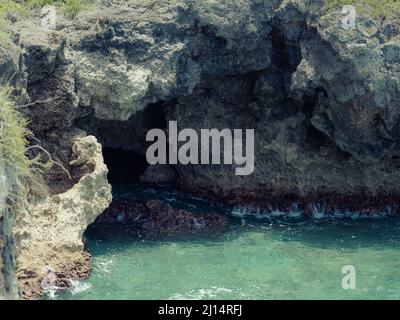 La foto mostra l'Oceano Atlantico con una costa rocciosa. La spiaggia esotica dell'isola contiene molte rocce e grotte. Il paesaggio roccioso e il mare sono Foto Stock