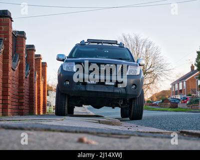 Una grande auto fuoristrada (suv) parcheggia sul marciapiede, limitando lo spazio per i pedoni. Sulla vettura manca una targa anteriore. Foto Stock