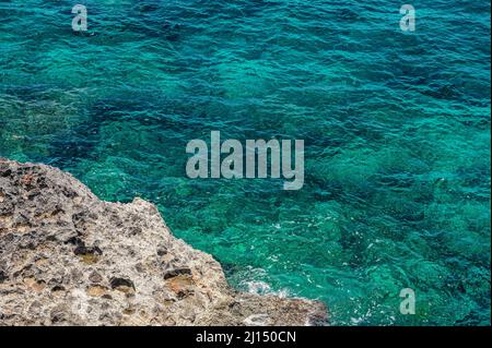 La foto mostra l'Oceano Atlantico con una costa rocciosa. La spiaggia esotica dell'isola contiene molte rocce e grotte. Il paesaggio roccioso e il mare sono Foto Stock