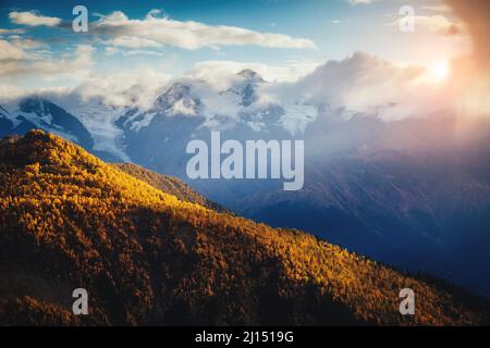 Bella vista sui piedi del Monte Ushba illuminato dalla luce del sole. Scena del mattino drammatica e pittoresca. Località famosa Place Mestia, Upper Svaneti, Geo Foto Stock