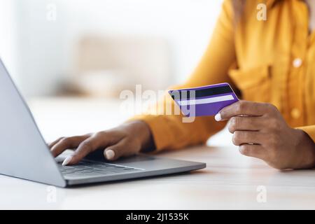 Ritagliato di donna afroamericana usando il computer e la carta di credito Foto Stock