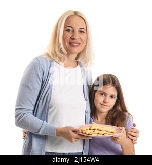 Donna matura, sua nipote e piatto con biscotti su sfondo bianco Foto Stock