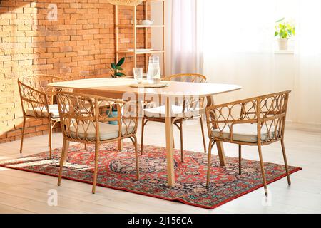 Interno di una moderna sala da pranzo con tavolo e tappeti vintage Foto Stock