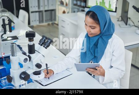 Il lavoro in laboratorio è stato sempre più utile. Scatto di un giovane scienziato che usa un tablet digitale mentre conduce la ricerca in un laboratorio. Foto Stock