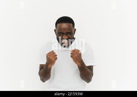 Buona fortuna. Eccitato pazzo africano americano ragazzo gridare di gioia mentre rendendo il gesto vincitore isolato su sfondo bianco. Vincitore e concetto di vittoria Foto Stock