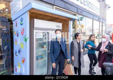 NEW YORK, NY – MARZO 22: United States Congresswoman Alexandria Ocasio-Cortez Restocks un frigorifero di quartiere fuori dal ristorante Queensboro a Jackson Heights il 22 Marzo 2022 a New York City. Il rappresentante Alexandria Ocasio-Cortez presenta un annuncio che celebra i proprietari e i lavoratori del ristorante Queensboro nel quartiere Jackson Heights per aver servito oltre 500 pasti ai membri della comunità che si trovano ad affrontare l'insicurezza alimentare durante il culmine della pandemia COVID-19. Credit: Ron Adar/Alamy Live News Foto Stock