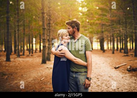 Siamo benedetti ad essere insieme. Scatto di una coppia amorevole che si abbraccia l'un l'altro in un abbraccio mentre si levano in piedi fuori nei boschi. Foto Stock