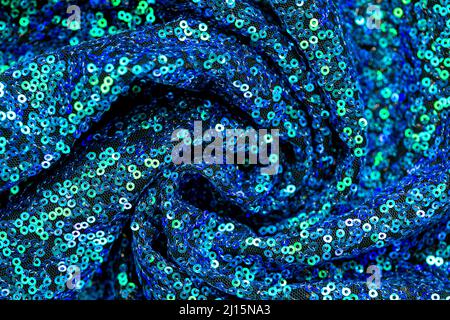 Sequins blu verde background.Shiny blu e tessuto verde.Artigianato e hobby. Tessitura e ricamo con paillettes. Foto Stock