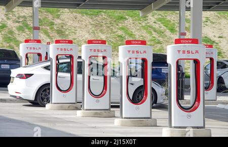 Kettleman City, CA - 29 gennaio 2022: Molte auto in carica presso una stazione Supercharger Tesla. Le stazioni Supercharger consentono alle auto Tesla di essere caricate rapidamente alla Foto Stock