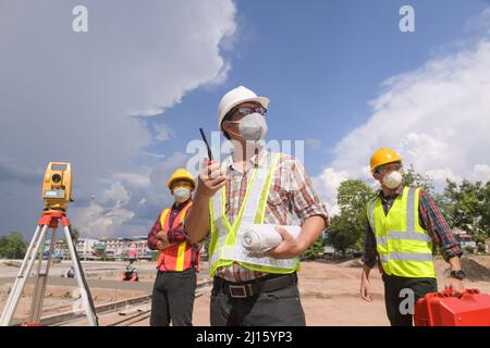 Surveyor ingegnere lavoratore di misurazione con teodolite su strada works.Survey ingegnere in cantiere. Foto Stock