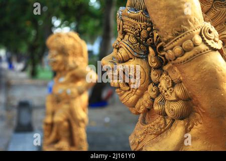 Due statue custode dorate accanto a Kuta Beach a Bali, Indonesia Foto Stock