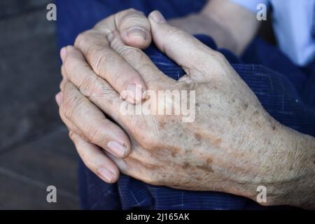 Mani aggrappate di vecchio Myanmar asiatico. Concetto di artrite reumatoide, osteoartrite o dolore articolare. Foto Stock